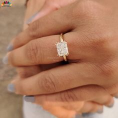 a woman's hand with a ring on it and a diamond in the middle