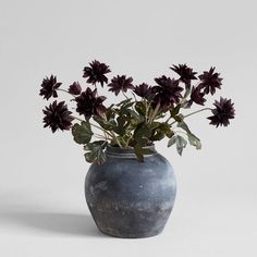 a vase filled with purple flowers on top of a table