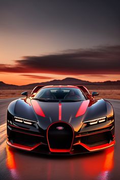 a black and red bugatti car driving down a road at sunset with mountains in the background