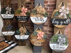 several wooden signs hanging on the side of a brick building with bows and ribbons attached to them