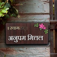 a sign that is on the side of a wooden building with flowers and leaves around it