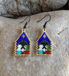 a pair of beaded earrings sitting on top of a rock