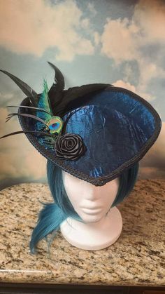 Beautiful Teal Victorian Inspired Hat with a Black Rose, Peacock and Black Feathers. Perfect for dressing up, formal events, Vampire Balls, and cosplay. Other styles are available in all colors. Message me for a custom order. Made in a pet friendly studio. Made to order. 3 to 5 days creation time. Check out my other listings: Black Velvet Victorian with Tassels: https://www.etsy.com/listing/1197594531/black-velvet-formal-hat-velvet-top-hat Silver Victorian: https://www.etsy.com/listing/1293744756/victorian-hat-edwardian-hat-downton Mauve Victorian:  https://www.etsy.com/listing/1293745798/mauve-velvet-hat-formal-hat-red-top-hat Burgandy Victorian:  https://www.etsy.com/listing/1094341893/victorian-hat-edwardian-hat-downton Turquoise Peacock: https://www.etsy.com/listing/1101444884/turquois Steampunk Peacock, Pirate Captain Hat, Peacock Hat, Steampunk Hats, Feathered Hat, Tea Hat, Teal Hat, Hat With Feather, Mauve Velvet