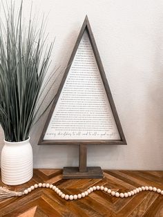 a wooden table with a white vase on it and a string of beads next to it