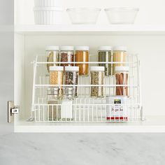 an organized spice rack in a white kitchen