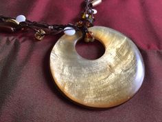 "80s Brown Boho Shell Necklace by Coldwater Creek. Measures about 20\" plus 2.5\" shell medallion. Creamy gold Mother of Pearl circle suspended from black rope strung with Glass and Metal Earthtone beads. Also, please take a look at my storefront at: https://www.etsy.com/shop/FabFinds42?ref=seller-platform-mcnav I have a wide selection of one-of-a-kind items, from clothing and toys to home decor and gift items, and I add new things almost every day." Handmade Vintage Gold Shell Necklace, Vintage Gold Necklace For Beach, Organic Necklace, Orange Bracelet, Beach Necklace, Beach Necklaces, Brown Necklace, Coral Bracelet, Black Rope