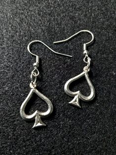 Add a touch of elegance and mystery to your style with our .995 Sterling Silver Poker-Suit Spade Earrings. Expertly crafted from genuine .995 sterling silver, these earrings feature the iconic spade symbol, representing wisdom, action, and a love for the game. These earrings showcase a sleek and polished finish, making them a versatile accessory for any outfit. Whether you're a poker enthusiast, a lover of unique jewelry, or simply looking for a stylish statement piece, these earrings are the pe Classic Hypoallergenic Dangle Jewelry, Classic Sterling Silver Jewelry For Pierced Ears, Cadmium-free Classic Silver Jewelry, Classic Hypoallergenic Earrings As A Gift, Classic Sterling Silver Pierced Earrings, Classic Nickel-free Jewelry For Anniversary, Classic Jewelry With Ear Wire For Gift, Silver Symbolic Hypoallergenic Earrings, Silver Hypoallergenic Symbolic Earrings