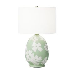 a green and white flowered vase lamp with a white shade on the top, against a white background