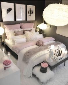 a white bed sitting in a bedroom on top of a fluffy rug next to two lamps