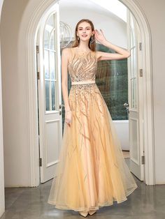 a woman standing in front of an archway wearing a dress with gold sequins