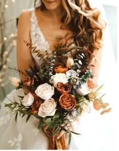 a bride holding a bouquet of flowers in her hands and smiling at the camera with lights behind her