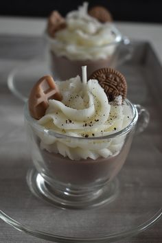 cupcakes with white frosting and chocolate decorations in glass cups on a tray