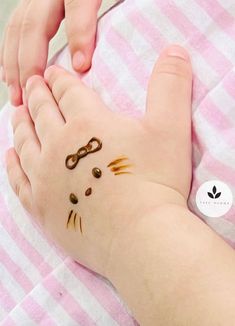 a child's hand with scissors on it and cat face drawn on the foot