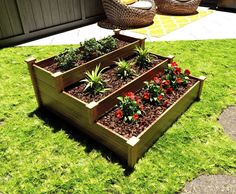 two wooden planters filled with plants on top of green grass next to a patio