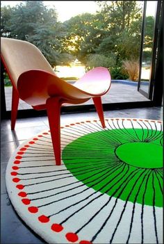 a chair sitting on top of a rug in front of a large glass window with trees outside