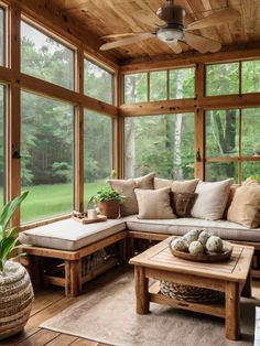 a living room filled with lots of windows and furniture next to a large window covered in wood