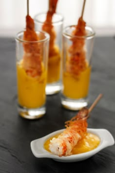 shrimp skewers in small glass cups on a table