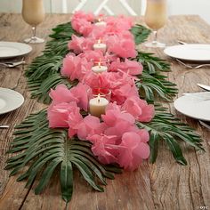 a long table with pink flowers and candles on it