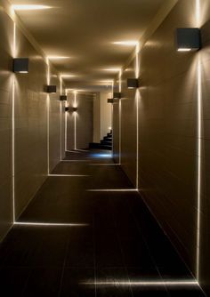 an empty hallway with lights on the walls