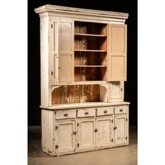 an old white cabinet with drawers and cupboards on it's sides, against a black background