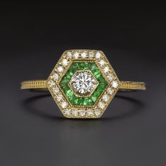 Why we love it: This Art Deco style diamond and emerald ring features a vibrant round brilliant cut diamond surrounded by a hexagonal double halo! Highlights: - Vibrant 0.20ct round brilliant cut diamond center - Bright white and 100% eye clean with grades of F-G SI1-SI2 - Calibre cut natural emeralds - Natural diamond accent stones - Unique and elegant vintage style design - Classic 14k yellow gold setting Dimensions: 10.6mm across (north-south) and 3.4mm from the finger to the top of the ring An appraisal is available upon request. All of our pieces come with a 30 day return policy and 100% satisfaction guarantee. --Details-- Center Stone: Diamond Color: F-G Clarity: SI1-SI2 Shape: Round Carat Weight: 0.20ct (approx) Side Stones: Diamonds, Emeralds Color: G-H, Green Clarity: SI Shape: Ro Halo Highlights, Diamond And Emerald Ring, Diamond Emerald Ring, Art Deco Emerald Ring, Smaragd Ring, Emerald Color, Double Halo, Art Deco Stil, Ring Art Deco