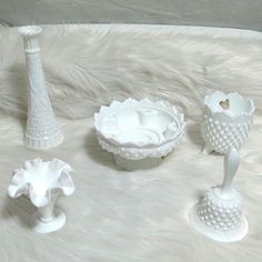 three white vases sitting on top of a fur covered floor