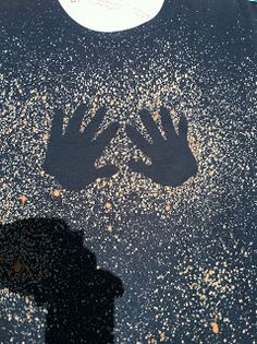 the shadow of a person's hand is shown in front of a street sign