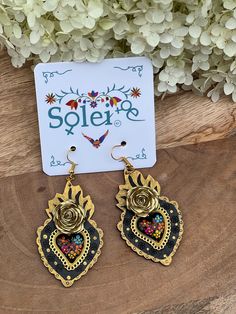 Infuse your style with a dash of Mexican charm with our hand-painted heart earrings. Each pair is meticulously crafted by skilled artisans, capturing the essence of Mexico's rich culture and artistic heritage.  Every piece is completely unique because of the detailed process that goes into creating it. The black lacquer is created by mixing in layers of dirt with a grease from the Cochinilla bug. The flowers are painted on with our finger tips using ground up natural pigments and linseed oil. To Heart-shaped Pierced Earrings For Festivals, Nickel-free Heart Earrings For Festivals, Traditional Heart Earrings As Gift, Nickel Free Heart Earrings For Festivals, Traditional Heart Earrings For Pierced Ears As Gift, Artisan Heart Earrings As Gift, Artisan Heart Earrings For Pierced Ears As Gift, Hand Painted Earrings For Festivals, Traditional Nickel-free Heart Earrings For Gift