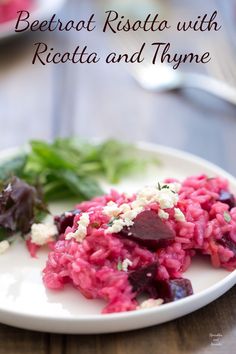 beetroot risotto with ricotta and thyme on a white plate