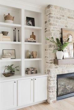 a living room filled with lots of white furniture and bookshelves next to a fire place