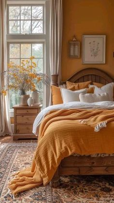 a bedroom with yellow walls and orange bedding, rugs and pillows on the floor