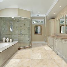 a large bathroom with two sinks and a walk in shower next to a bathtub