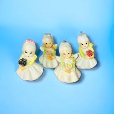 four little figurines are sitting on a blue surface