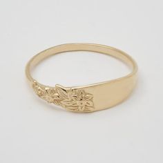 This vintage-inspired gold flower signet ring is a row of dainty flowers wrapped around your fingers. Handmade and polished, it is available in 14K gold.This item is engravable with text or monogram of your choice at no extra cost. The initials are engraved into the inside or on the outside of the ring and embedded in the 3D model for a flawless embossed finish. A few notes about our gold:- Though we do not hallmark the insides of all our rings (it can interfere with the outside design), please Gold Engraved Delicate Rings, Delicate Gold Engraved Rings, Delicate Engraved Gold Rings, Delicate 14k Gold Engraved Ring, Delicate Engraved 14k Gold Ring, Victorian Style Rings, Signet Rings Women, Dainty Flowers, Monogram Ring