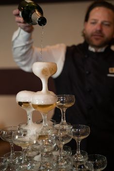 a man pouring champagne into wine glasses