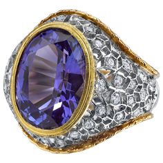 A deep, periwinkle blue tanzanite weighing 8.25 carats is featured in this beautiful Florentine inspired ring set with round brilliant cut diamonds. The intricately pierced and engraved details of this ring display the skills required to create such a stunning piece of jewelry. Such fine craftsmanship is seldom seen today. Handmade in Italy of 18k yellow and white gold. Ring size 7 Complimentary sizing as needed Tanzanite, 14.00 x 10.30 x 8.6mm, 8.25 carats 36 round brilliant cut diamonds, .96 c Deep Periwinkle, Dome Rings, Vintage Cocktail Ring, Gem Diamonds, Tanzanite Diamond, Tanzanite Ring, Blue Tanzanite, Coral Jewelry, Periwinkle Blue