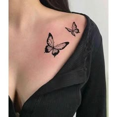 a woman's shoulder with two butterflies on it, one is black and the other is white