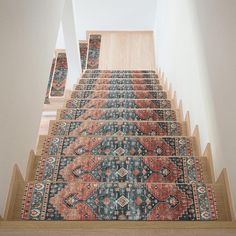 a carpeted stair case with multiple rugs on it