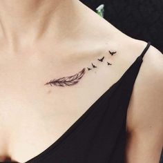 a woman with a tattoo on her chest has birds flying in the sky above her shoulder