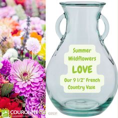 a vase filled with lots of flowers next to a sign that says summer wildflowers love our 9 / 12 french country vase