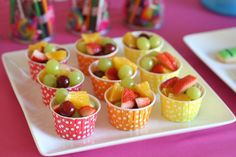 an image of some fruit cups on a plate with strawberries and grapes in them