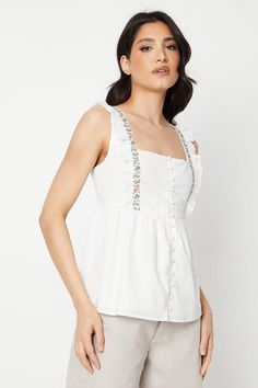 Sleeveless woven blouse with embroidered detailing
Square neckline with adjustable tie straps
Gathered bust with button-front placket
Relaxed fit through the body
Lightweight and breathable fabric
This embroidered sleeveless blouse from Dorothy Perkins exudes sophistication and versatility. The square neckline with adjustable tie straps allows for a customised fit, while the gathered bust and button-front placket add a touch of femininity. The relaxed fit through the body ensures comfort and ease of movement. Style this blouse with tailored trousers and heels for a smart casual look perfect for brunch with friends or a baby shower. Alternatively, pair it with a midi skirt and ballet flats for a refined daytime ensemble. Embroidered Sleeveless Vest For Spring, Sleeveless Embroidered Spring Vest, Sleeveless Embroidered Vest For Spring, Spring Embroidered Sleeveless Vest, Spring Sleeveless Embroidered Vest, Sleeveless Embroidered Vest For Summer, Summer Sleeveless Embroidered Vest, White Embroidered Cami Tank Top, Cotton Cami Top With Floral Embroidery