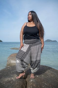 "Black striped plus size harem pants made from 100% Thai rayon. These trousers are so lightweight and comfortable.  They have a super stretchy, elasticated waistband so they fit most UK sizes 14-20 (US 10-16) and are elasticated around the ankles making the leg length adaptable.   These trousers are a popular choice for festival goers but are also great for yoga, pilates or just lounging around. Please refer to the measurements below: Measurements: One Size: Plus Total Length - 40\"/ 101cm Waist Plus Size Harem Pants, Striped Harem Pants, Genie Pants, Yoga Trousers, Pants Comfy, Festival Clothing, Plus Size Black, Aladdin, Festival Outfits