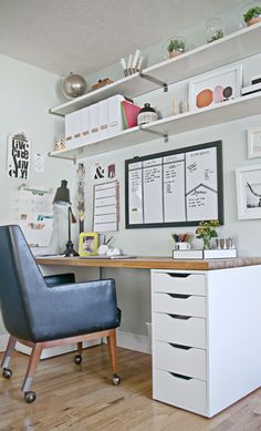 a desk with a chair and some pictures on the wall