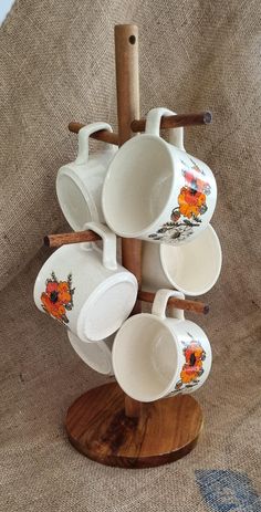 a wooden stand with cups and spoons on it, stacked up in the shape of a tree