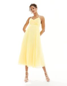 a woman in a yellow dress posing for the camera