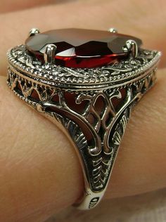 Red Garnet CZ Gemstone Teardrop RingTear Vic Design#D28 Inspired by Victorian and Art Deco designs, this high-quality filigree ring is handcrafted in sterling silver. This teardrop ring is set with an 8 carat pear cut flawless red CZ (Cubic Zirconia) gemstone. The gem is 16mm (~5/8") x 12mm (~1/2"). The gorgeous stone has a lovely vibrant color. The inside of the band is marked 925 for sterling silver. Notice the beautiful filigree of the silver setting. This is a ring with beauty and grace. The Ornate Red Teardrop Jewelry, Classic Red Pear-shaped Jewelry, Filigree Drop Jewelry For Anniversary, Red Victorian Filigree Ring For Anniversary, Classic Red Hand Set Jewelry, Classic Hand Set Red Jewelry, Classic Red Hand-set Jewelry, Red Oval Filigree Ring With Intricate Design, Red Filigree Ring For Anniversary With Intricate Design