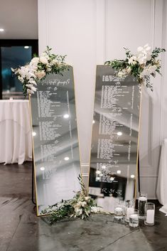 two large mirrors with flowers and greenery on them are sitting next to each other