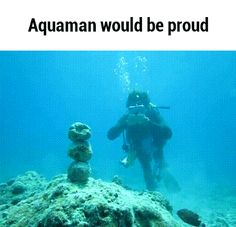 two people scubang in the ocean with rocks and corals on the bottom of the water