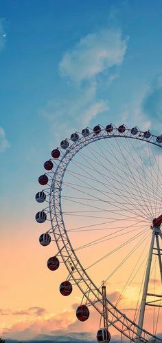 a ferris wheel in front of a cloudy sky